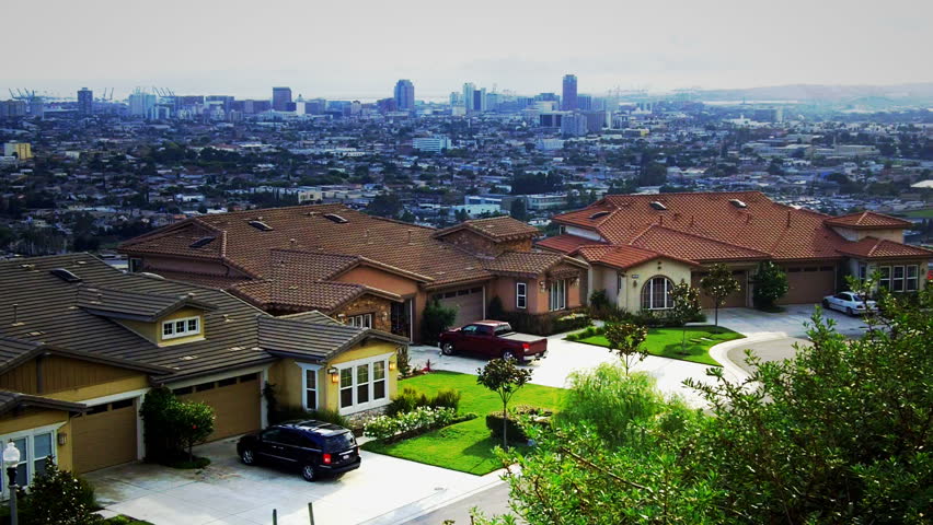 A street of new suburban houses in Long Beach, CA with the downtown area high