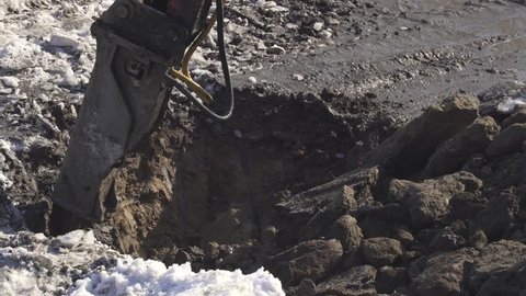 Breaker (hydraulic) cuts frozen soil. Stock footage video