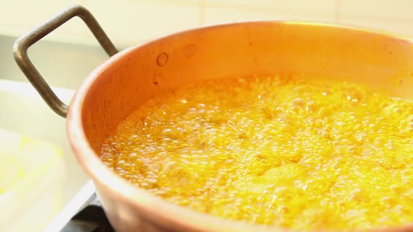 Orange marmalade cooking in a copper pot