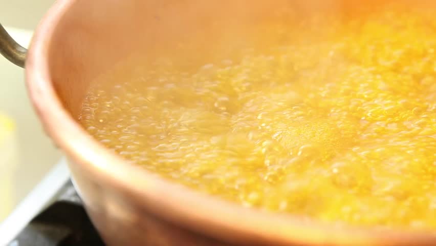 Orange marmalade cooking in a copper pot