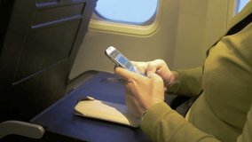 High quality video of woman using cell phone in the airplane in 4K