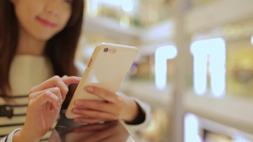 Woman use of mobile phone in shopping mall Royalty-Free Stock Footage #25384439