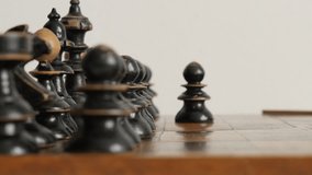 Wooden chess set figures arranged on game playing table 4K 2160p 30fps UltraHD footage - Black player pawn moving over chequered fields 3840X2160 UHD video