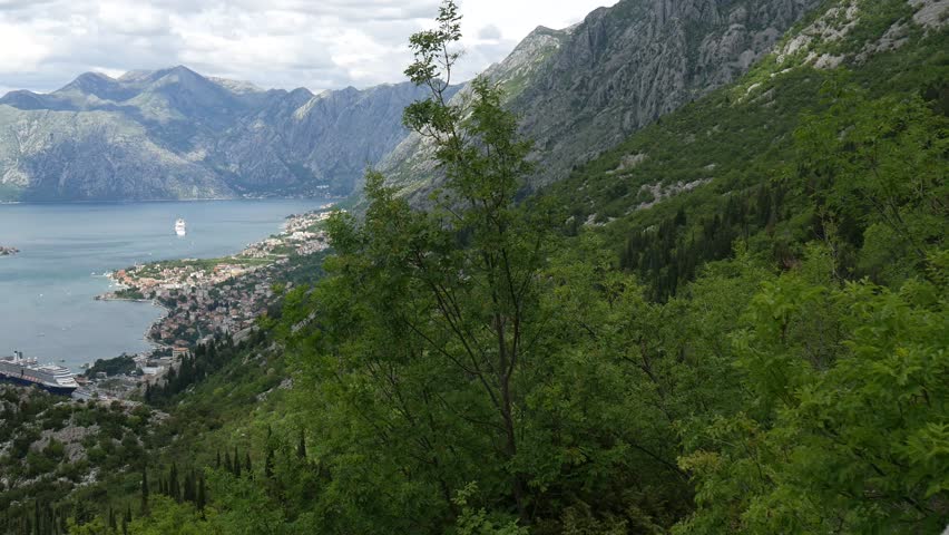 Bay of Kotor from the heights. View from Mount Lovcen to the bay. View down from the observation platform on the mountain Lovcen. Mountains and bay in Montenegro. The liner near the old town of Kotor.