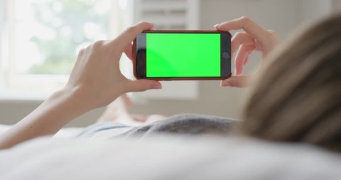 Close up Woman holding smartphone green screen chroma-key greenscreen sharing authentic social media