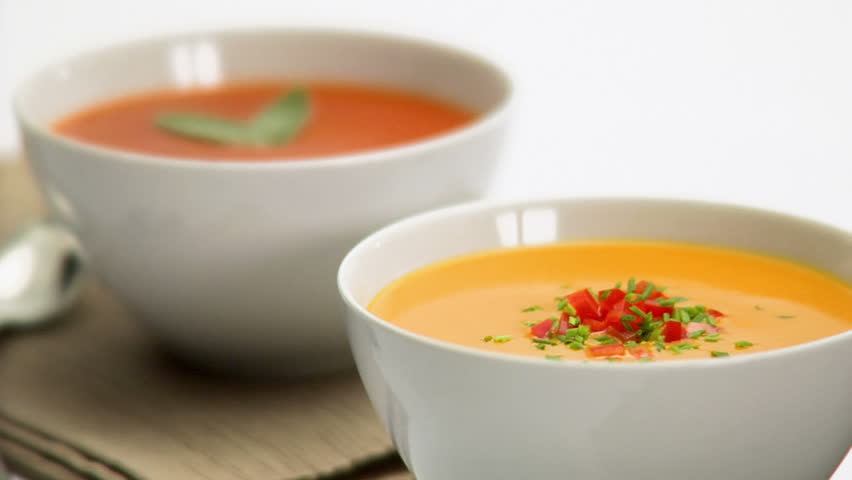 Two bowls of soup, with one red and the other yellow