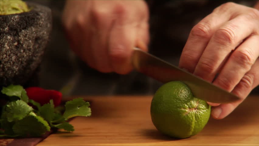 Follows action as chef slices a lime