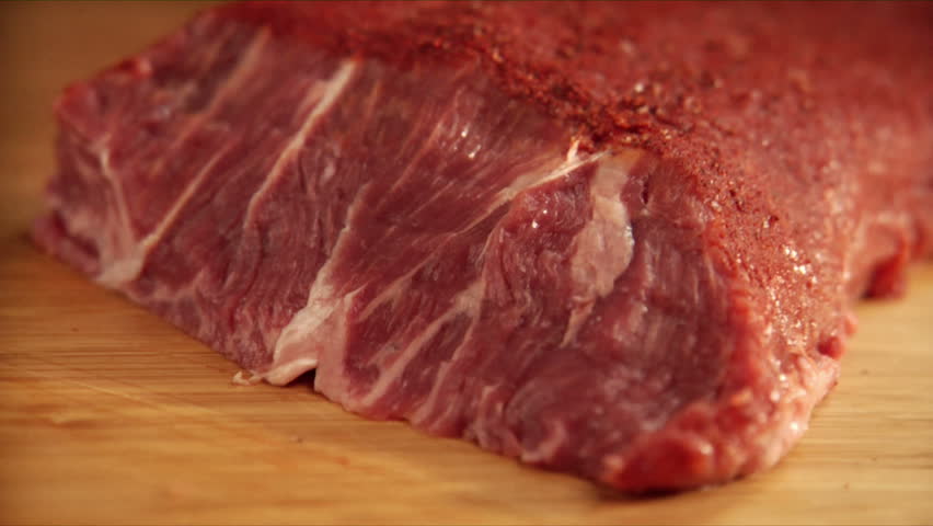 pan over chef slicing seasoned flat-iron steak