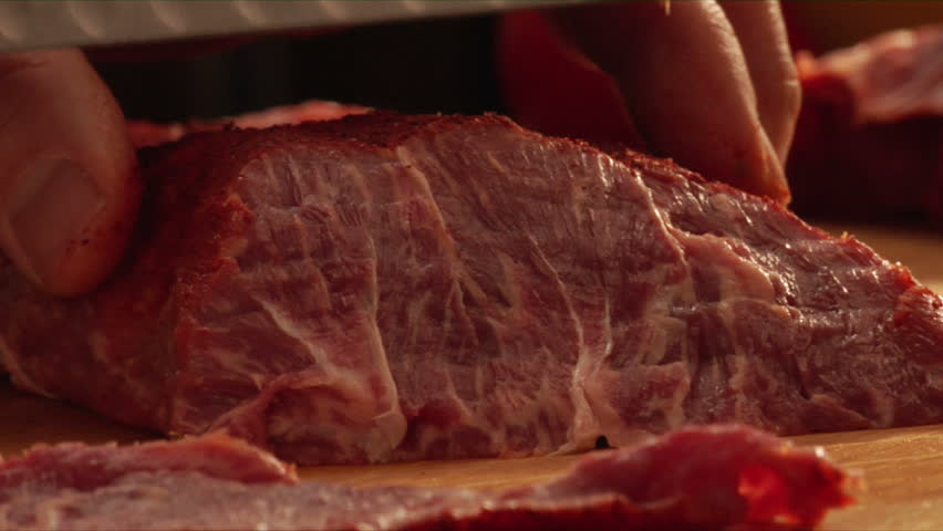 pan over chef slicing seasoned flat-iron steak
