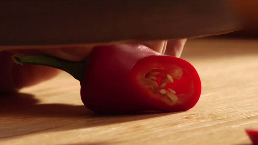 Chef slices red jalapeno pepper