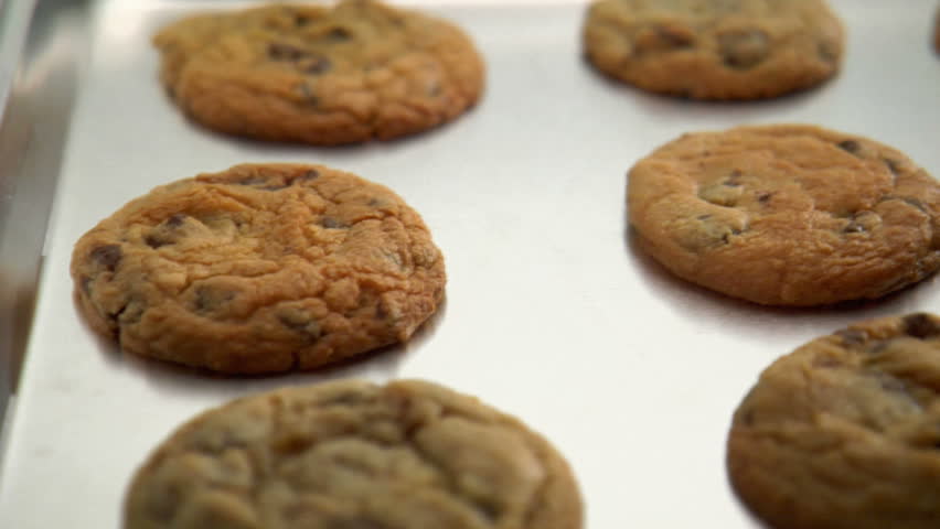 pan over tray of chocolate chip cookies, as spatula removes one cookie to