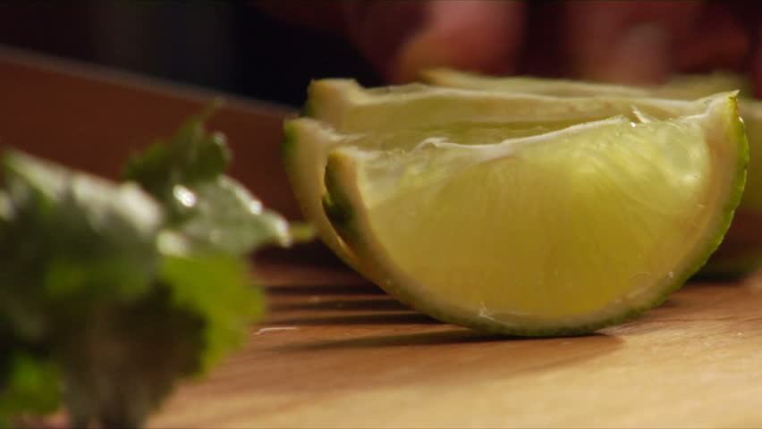 Follows action as chef slices a lime