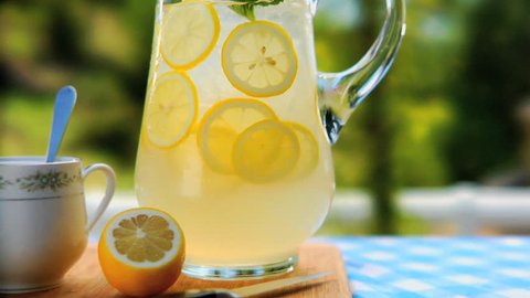 Pan over pitcher of lemonade to lemons on cutting board Stockvideó