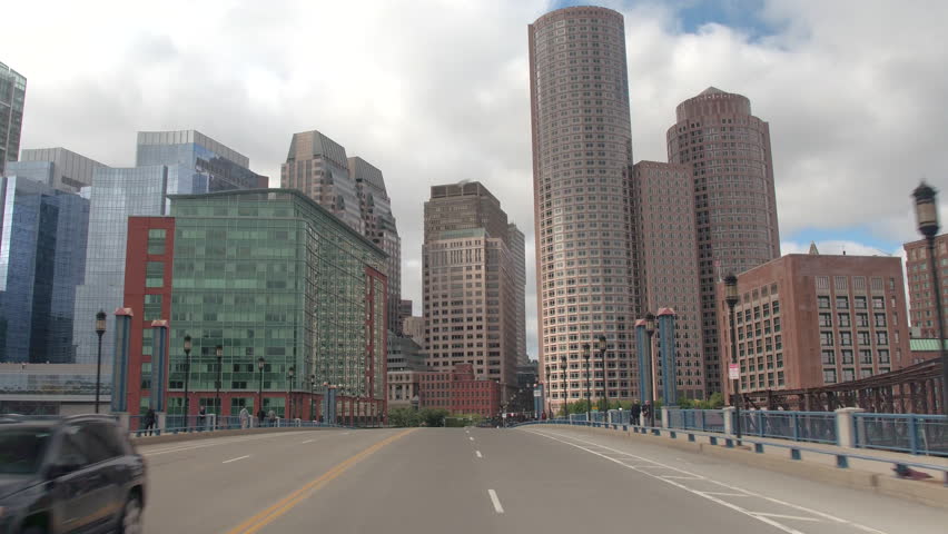 FPV, CLOSE UP: Traveling towards high glassy window pattern skyscrapers in Downtown Boston financial district skyline, USA. Driving on busy highway in metropolitan city overlooking office buildings