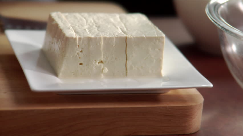 Close-up of chef slicing fresh tofu.