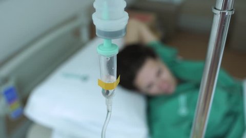 Young woman patient lying on a bed in hospital with infusion therapy