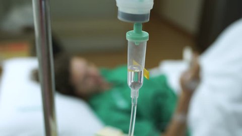 Female Patient Using Mobile Phone In Hospital Bed