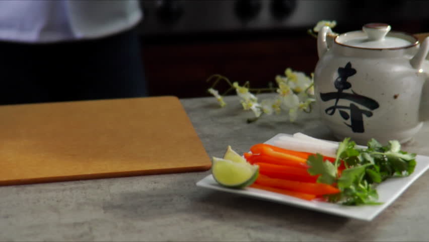 Lock down shot of chef placing skewers of shrimp on cutting board with place of