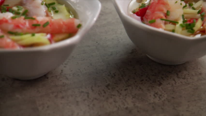 Close-up pan over shrimp and cucumber salad.