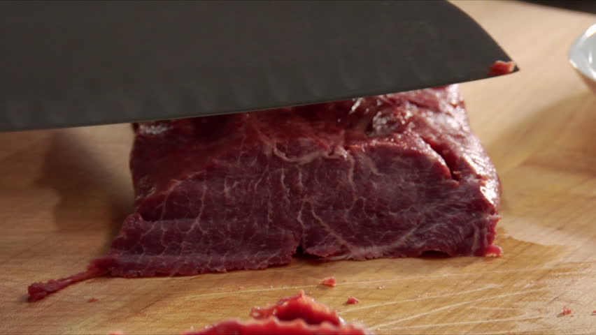 Close-up of chef slicing a few pieces of steam and placing with other slices.