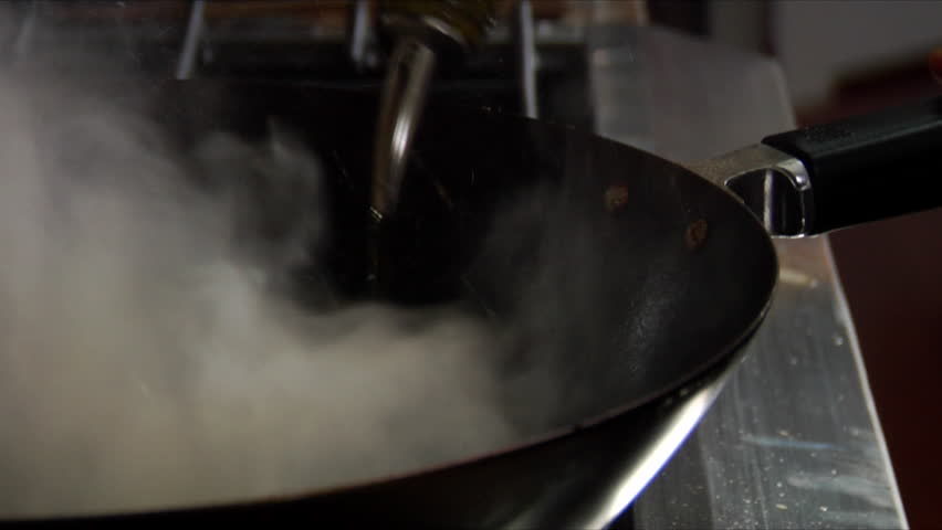 Close-up of chef flambeing wok