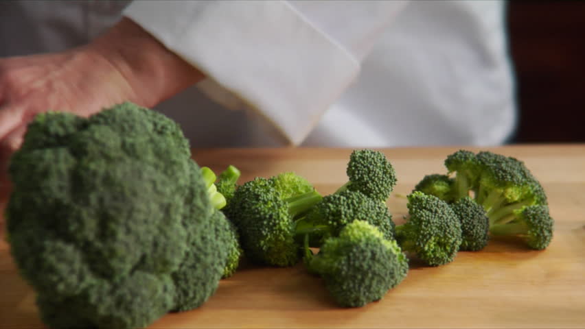 Lock down, close-up of chef preparing broccoli florets.