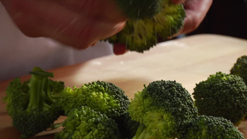 Close-up of chef chopping and separating broccoli florets.