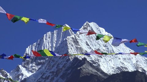 Tibetan prayer flags against white snowy mountain peak in the Everest region of Himalayan mountains, Nepal