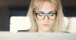 Businesswoman Wearing Eyeglasses While Using Laptop In Office