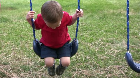 Alone kid swinging and smiling.  HD 1080i