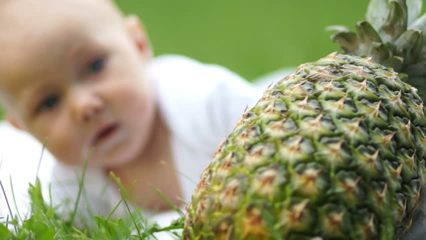 Baby boy looking at pineapple
