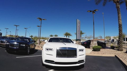 SCOTTSDALE AZ/USA: February 28, 2017- Drive by shot of shiny Bentley and Ferrari luxury cars at a dealership. Clip reveals row of expensive import vehicles in a automotive car lot.