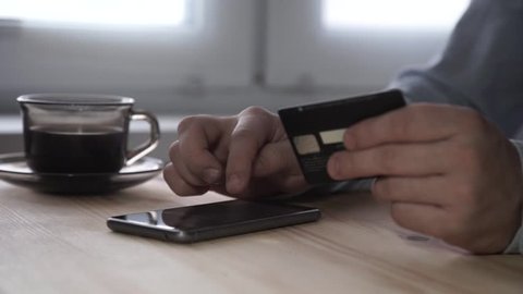 Buying online with a smartphone device and a credit card in the other hand.