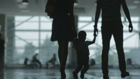 Woman man and child at the airport silhouettes