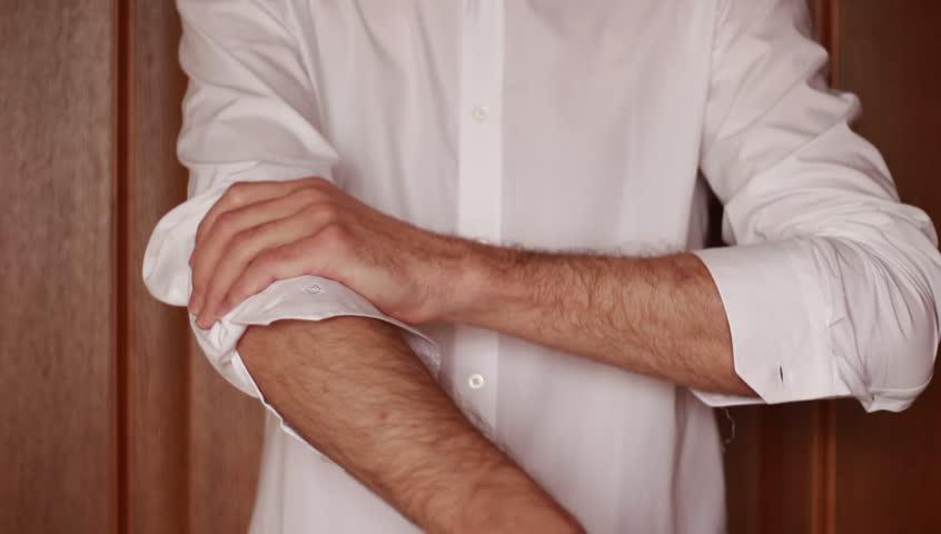 Man unbuttoning his shirt's sleeves