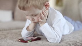 Child Watching Video, Playing on Phone Lying on Sofa