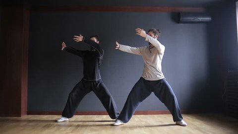 Twins brothers practice Tai Chi in the training hall