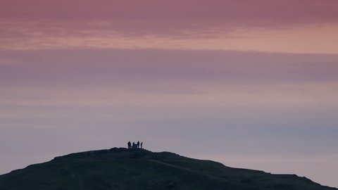 Group Of People On Hilltop At Sunset