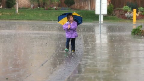 Young girl having fun walking in the rain