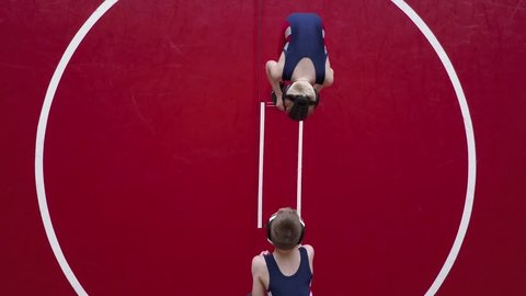Two youth wrestlers filmed from overhead.