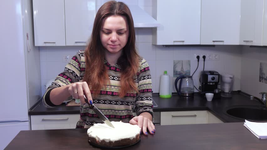 Girl brunette cuts cheese cake and puts them on saucer