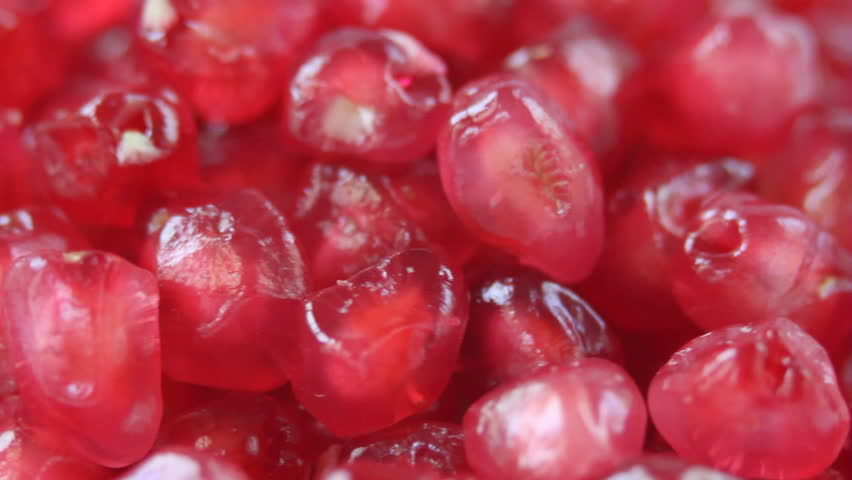 Ripe pomegranate seeds rotating in a loop. Macro shot.
