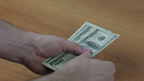Men's hands counting cash dollar bills