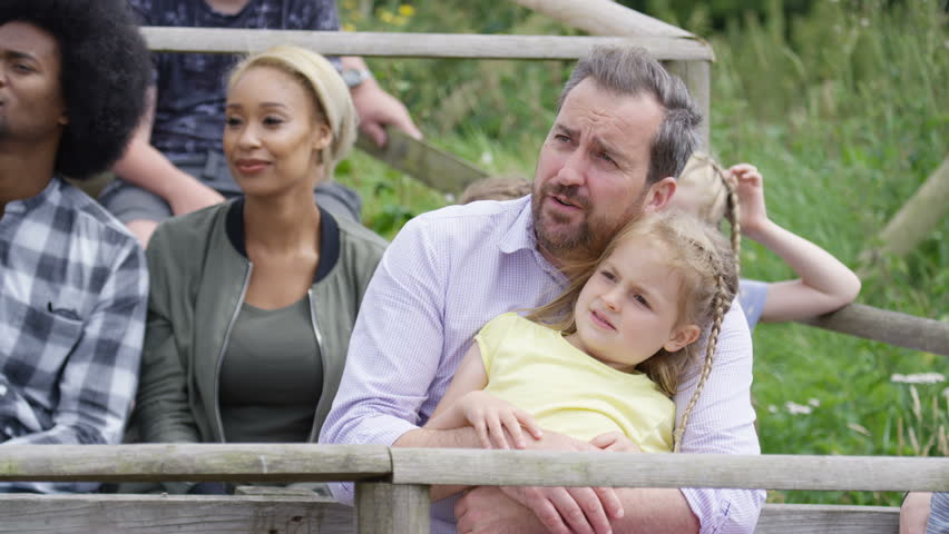 4K Families watching a demonstration at falconry center, focus on audience