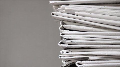 pile of newspapers, tracking shot of a stack of journals

