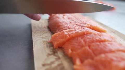 The cook cuts salmon fillet, chef prepares fish for cooking, dishes with fish, diet and healthy food