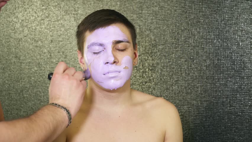 Makeup artist is covering young man