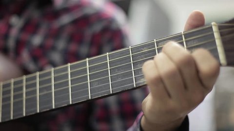 The guitarist's hand touches the guitar strings
