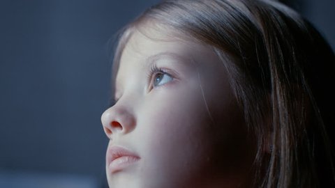 Close-up of a Cute Young Girls Face while She's Looking at Something that Illuminates Her Face. Shot on RED EPIC-W 8K Helium Cinema Camera.