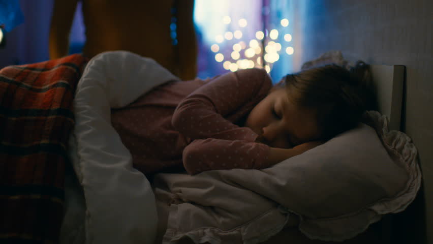 Sweet Little Girl Sleeps in Her Bed at Night, Her Mother Tucks Her Blanket in. Shot on RED EPIC-W 8K Helium Cinema Camera. Royalty-Free Stock Footage #25513337